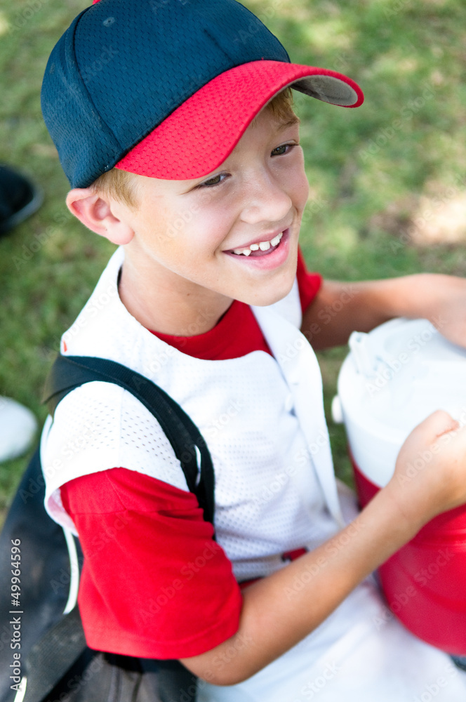 Little league baseball player happy after game.