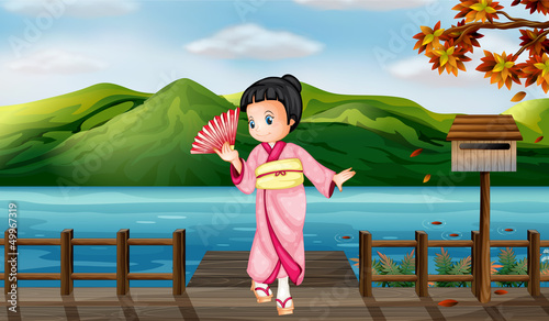 A girl wearing a chinese dress with a wooden mailbox