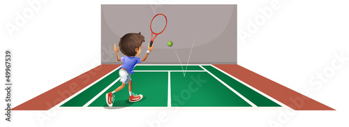 A boy playing tennis at the court