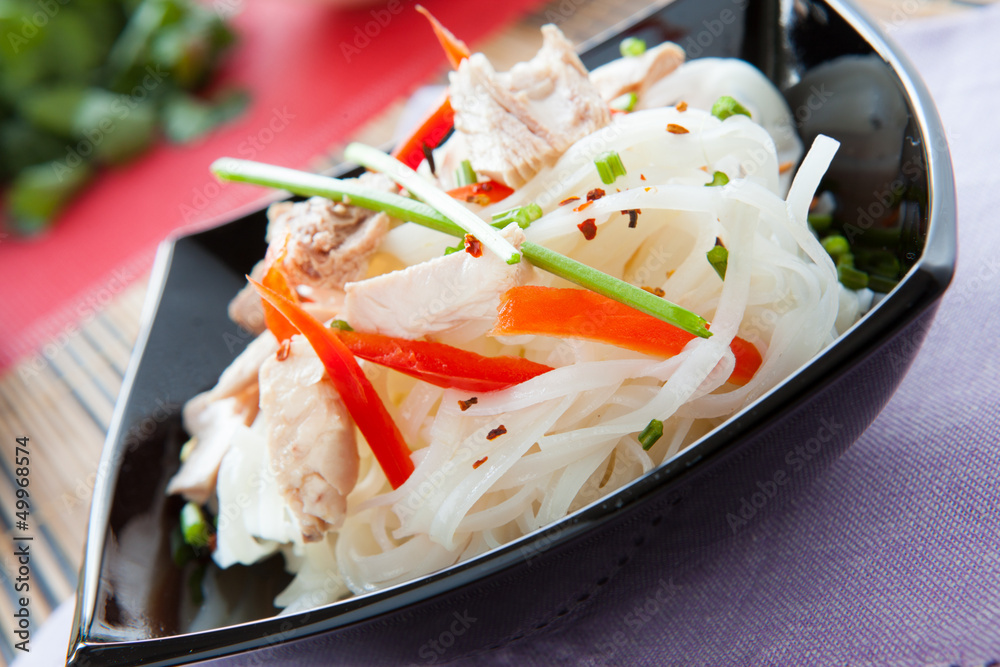 rice noodles with peppers and tuna in a black bowl rice noodles with peppers and tuna in a black bowl