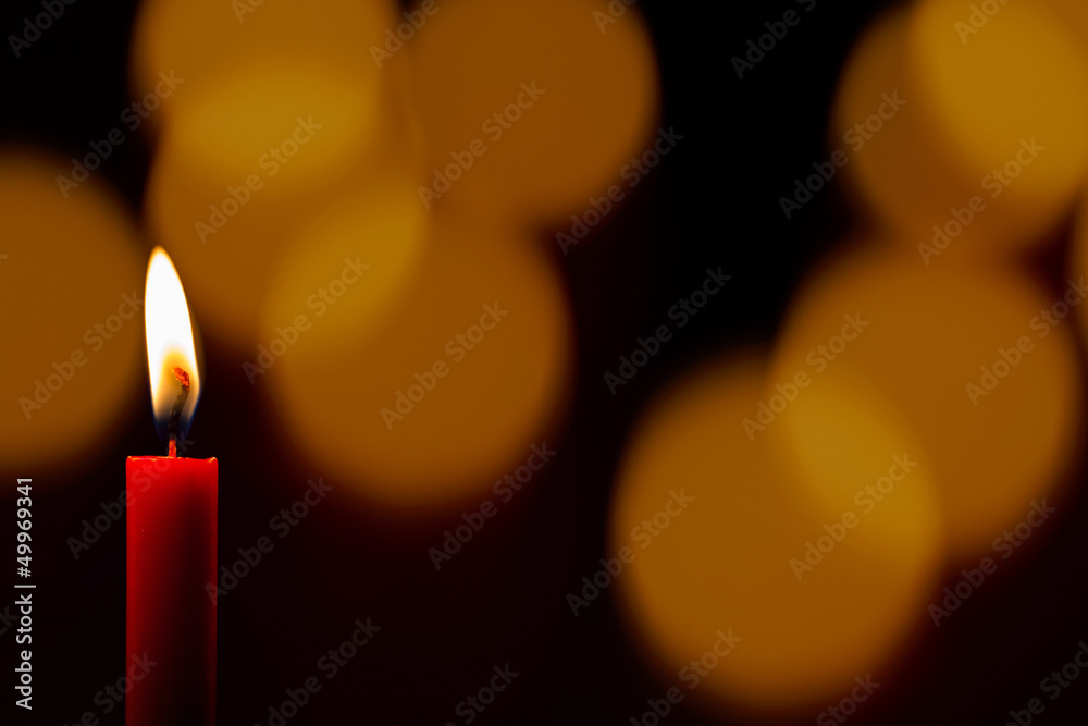 Einsame Kerze vor Lichterglanz