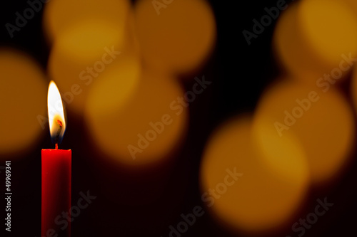 Einsame Kerze vor Lichterglanz photo