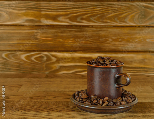 Coffee beans in a cup on a brown background