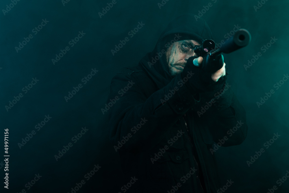 Sniper with beard in black holding gun. Studio shot. Sniper with beard in black holding gun. Studio shot.