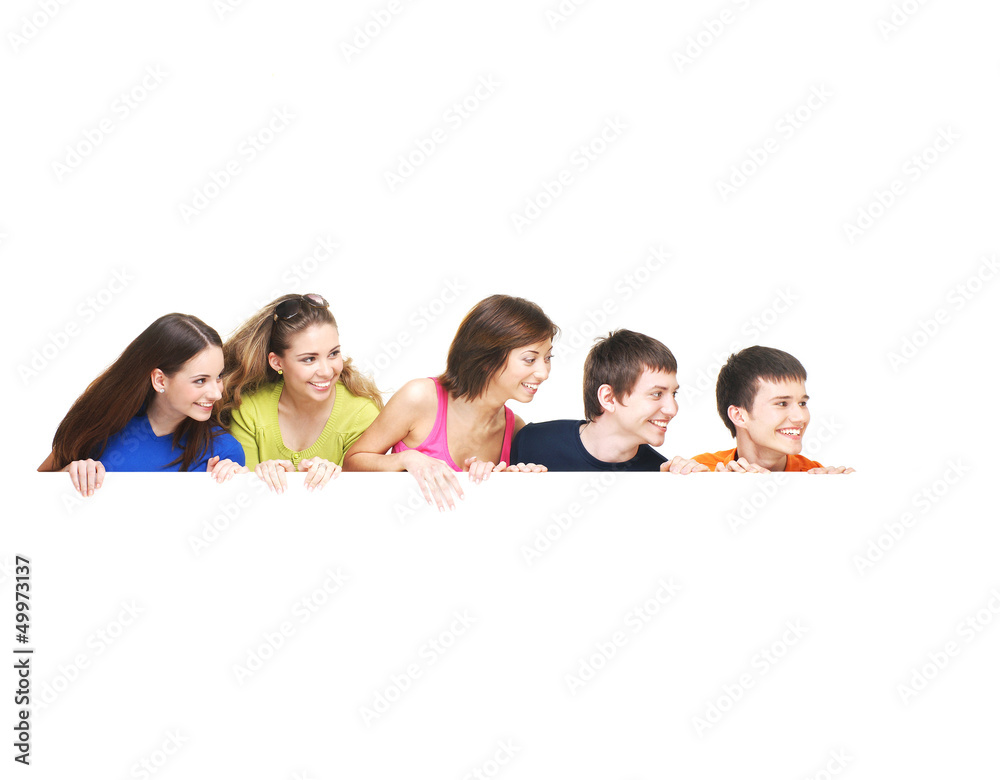 A group of happy teenagers holding a white blank banner A group of happy teenagers holding a white blank banner
