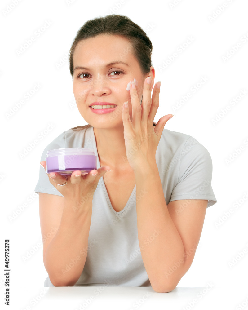 Isolated Middle Age Asian Woman apllies cream on her face. Isolated Middle Age Asian Woman apllies cream on her face.