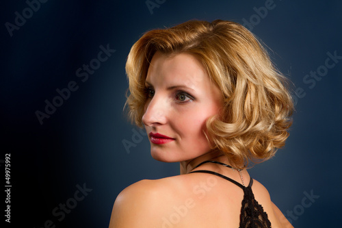 beautiful blonde girl on dark background with copyspace