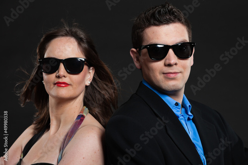 Happy young couple with black sunglasses. Studio shot.