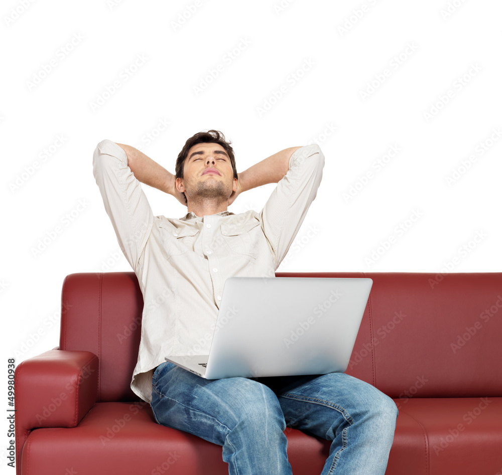 resting man with laptop sits on the divan resting man with laptop sits on the divan