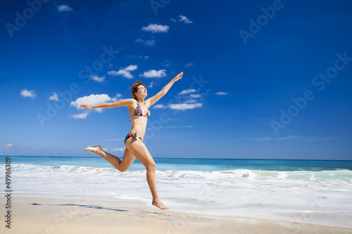 Woman jumping on the beach © ikostudio