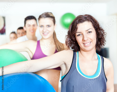 Group of people holding pilates ball at the gym