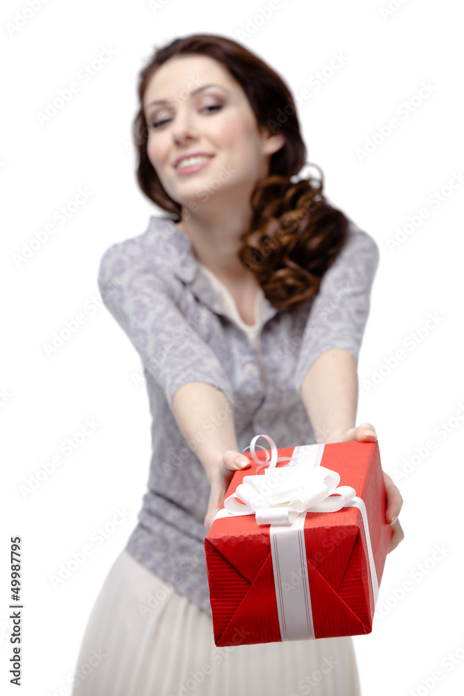Young woman offers a gift wrapped in red paper Young woman offers a gift wrapped in red paper