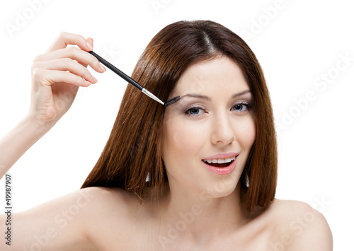 Woman putting on makeup with cosmetic brush