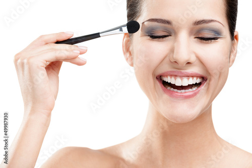 Woman applying make-up with brush, isolated on white