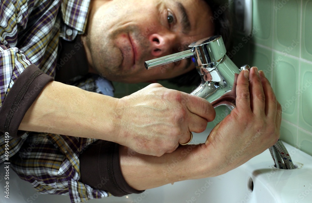 Mann installiert Wasserhahn an Waschbecken