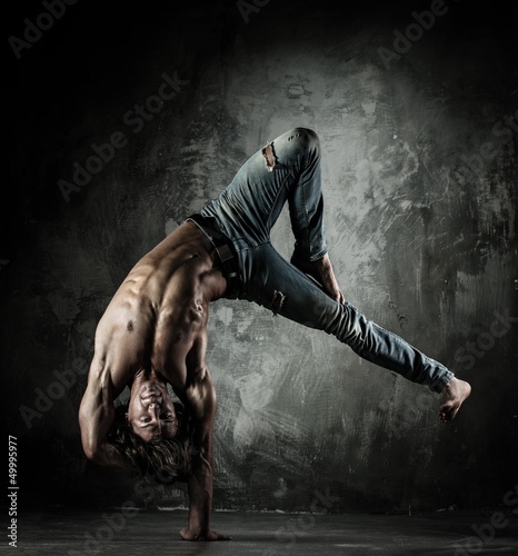 Young b-boy man with naked torso doing brake dancing movements photo