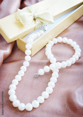 Pearl necklace on a beige silk fabric