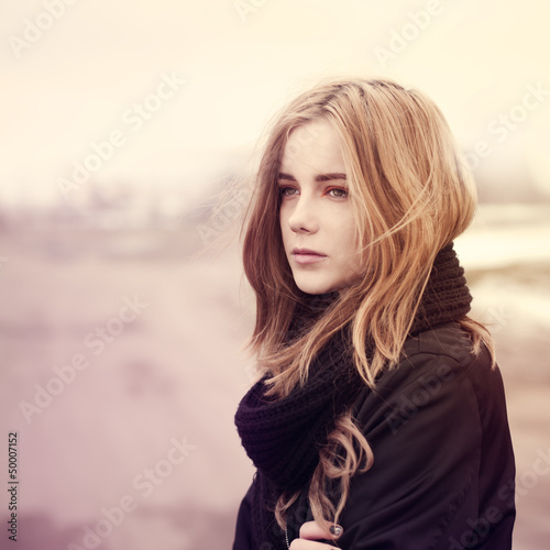 beautiful young girl standing on the road in winter