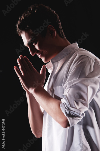 Low-key portrait of businessman praying for success