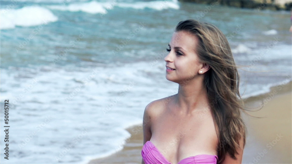 Young woman walking on the beach, slow motion shot at 240fps Young woman walking on the beach, slow motion shot at 240fps