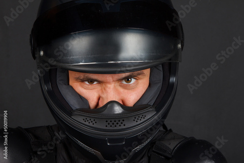 Man in bikers helmet with a defiant facial expression