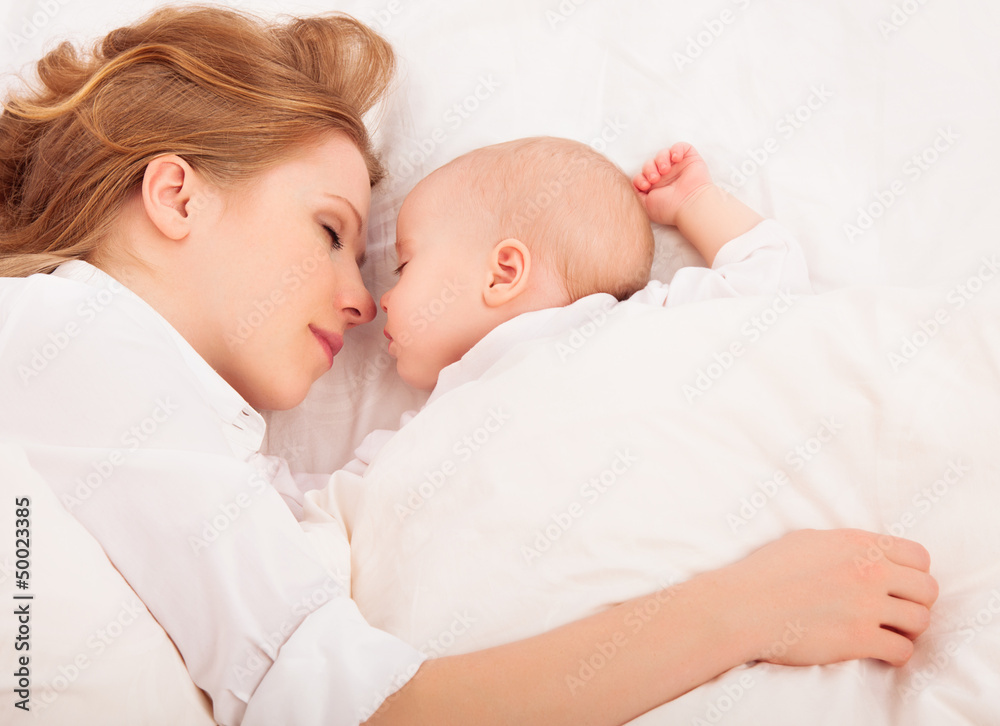 mother embraces the newborn baby sleeping together in bed mother embraces the newborn baby sleeping together in bed