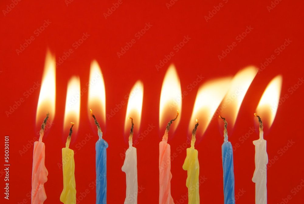 Eight burning candles on green background Eight burning candles on green background