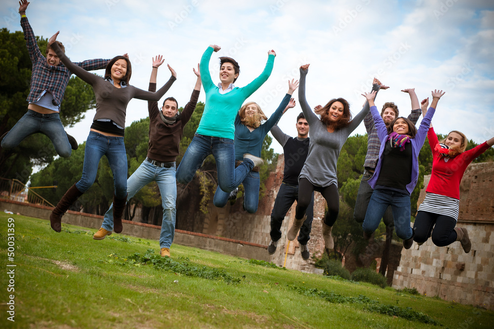 Obraz premium Group of Happy College Students Jumping at Park