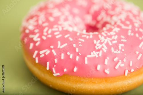 Pink donut on green background