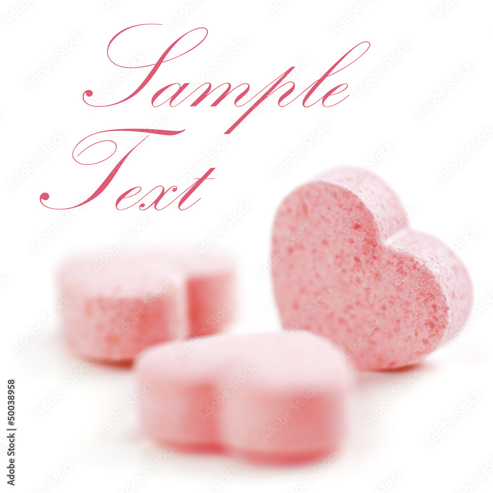 Obraz premium Sweet hearts shaped pink Sugar Pills. Soft Focus. Sample Text.