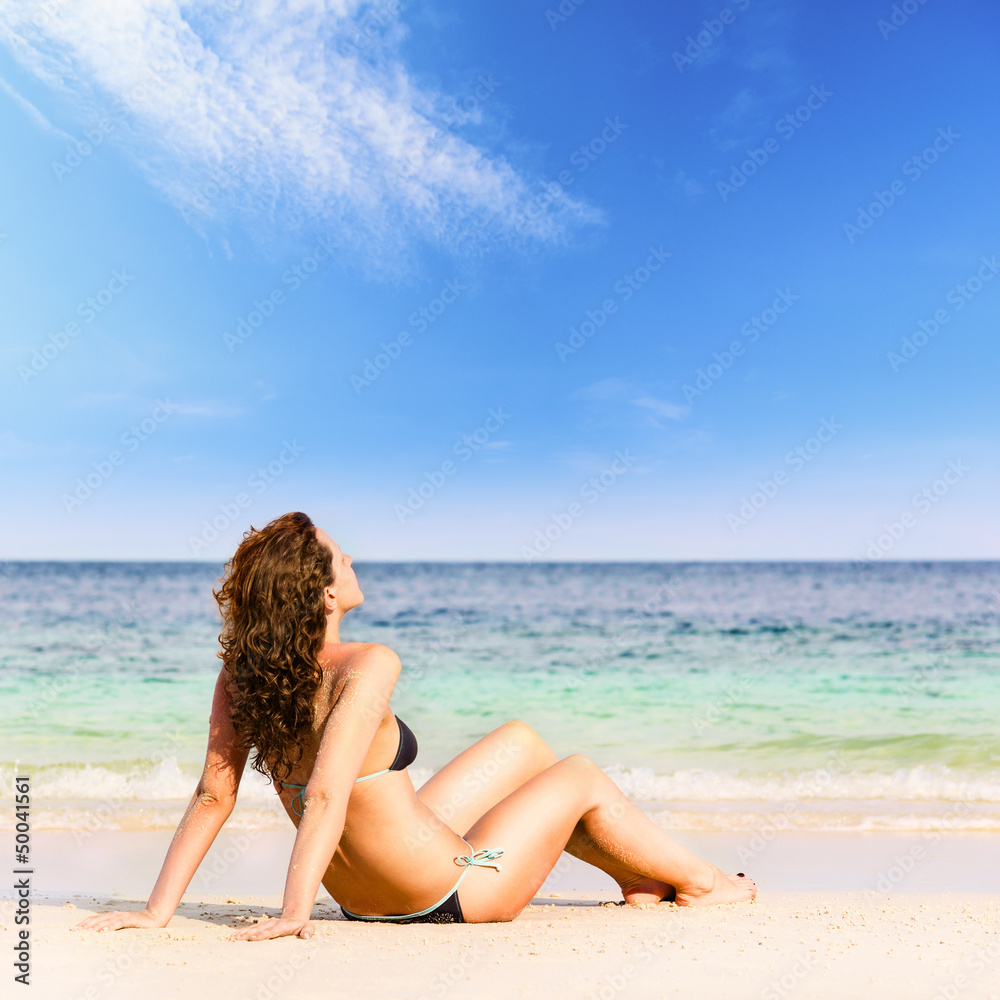 woman is sitting on beach