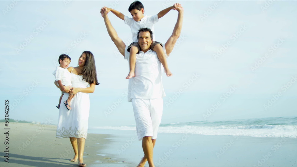 Hispanic parents spending holiday with children on beach Hispanic parents spending holiday with children on beach