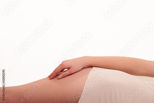 Leżąca dziewczyna trzyma dłoń na biodrze