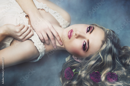 Studio portrait of beautiful woman with roses in the smoke