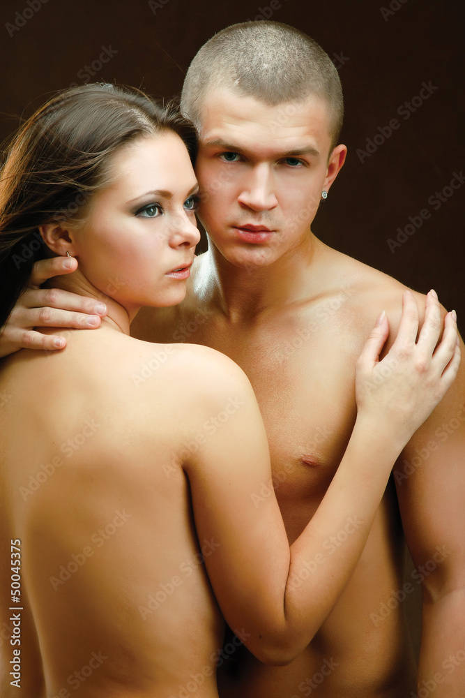 Young beautiful loving couple is embracing - on black background Young beautiful loving couple is embracing - on black background