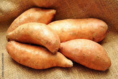 Close-Up of 5 Sweet Potatoes on Burlap