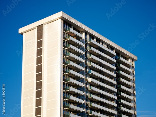 An 80s apartment building on the blue-sky day. photo