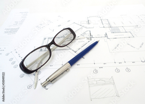 Glasses and a pencil with Architect’s plans.
