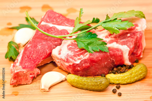 Raw beef with spices and vegetables on the cutting board