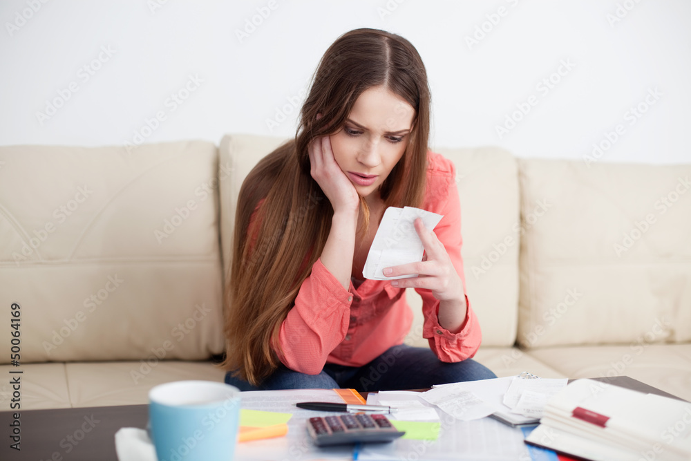 Stressed woman looking at bills Stressed woman looking at bills