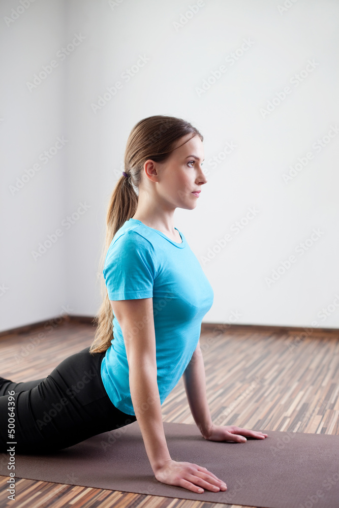 Young woman practicing yoga at home