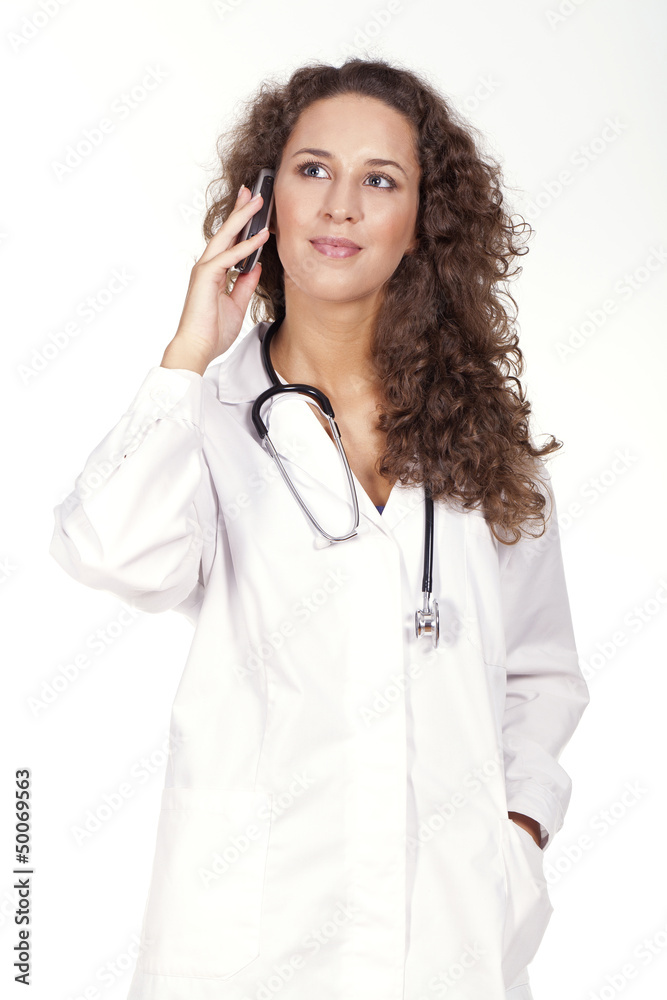 young female doctor standing and holding a cellphone young female doctor standing and holding a cellphone