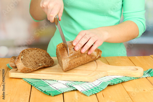 Woman slicing bread with sesame seeds