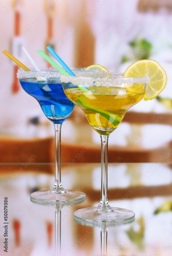 Yellow and blue cocktails in glasses on room background Yellow and blue cocktails in glasses on room background