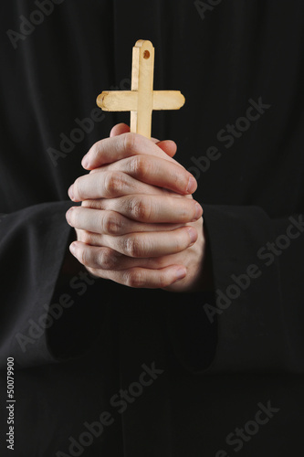 Priest holding cross, close up