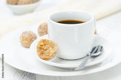 Homemade candy made of almonds, ginger and dates and cup of coff