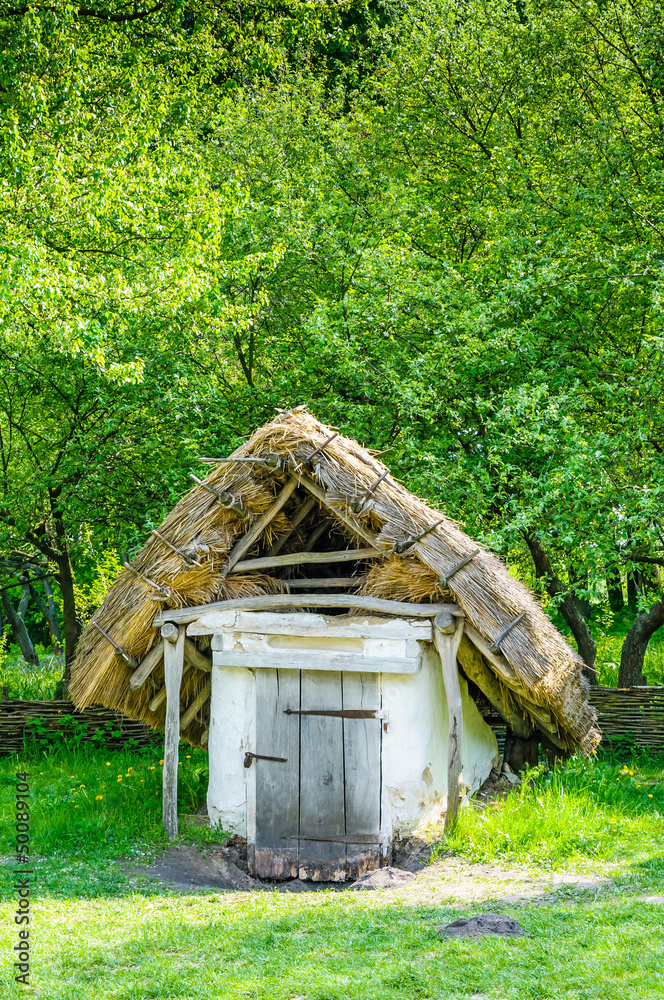 A typical antique Ukrainian wooden country hut with a thatch roof, in Pirogovo near Kiev A typical antique Ukrainian wooden country hut with a thatch roof, in Pirogovo near Kiev