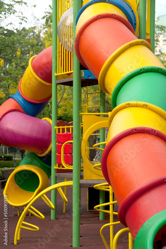 Colorful spiral tube slide at public playground .