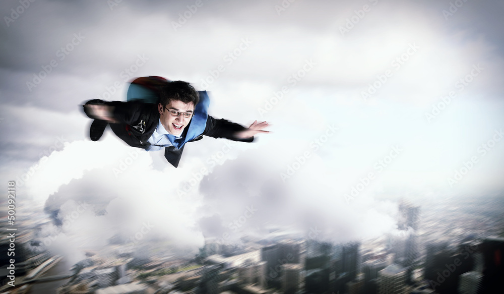 Young businessman flying with parachute on back Young businessman flying with parachute on back