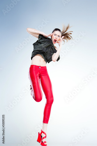 sexy model with slim body dressed in red jumping and screaming